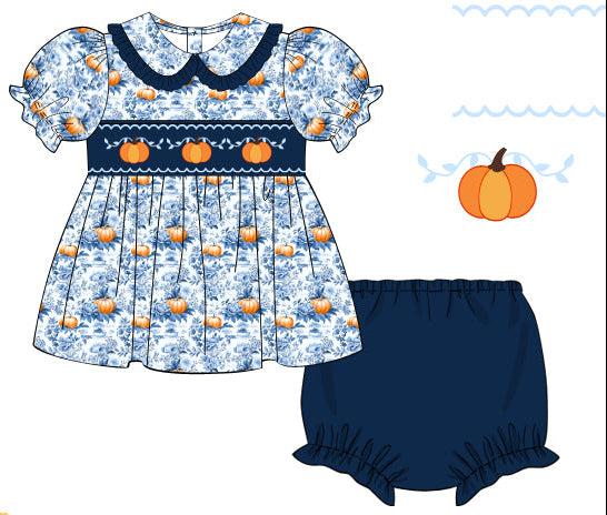 Children's dress with pumpkin pattern and matching bloomers on a white background