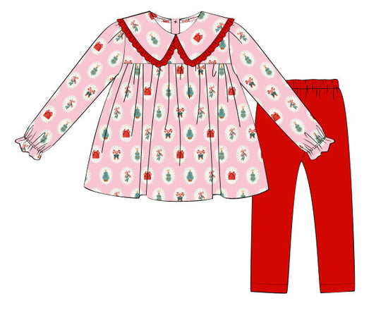 Children's outfit with pink patterned top and red pants on a white background