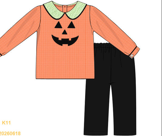 Children's outfit with orange checkered shirt and black pants featuring a jack-o'-lantern face on a white background.